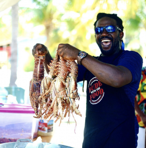 Man holding up giant lobsters with a smile on his face